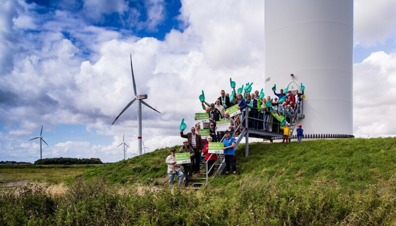 Menschen vor Windenergieanlage, der Michael-Sladek-Preis für Bürgerenergie wird erstmals ausgelobt.